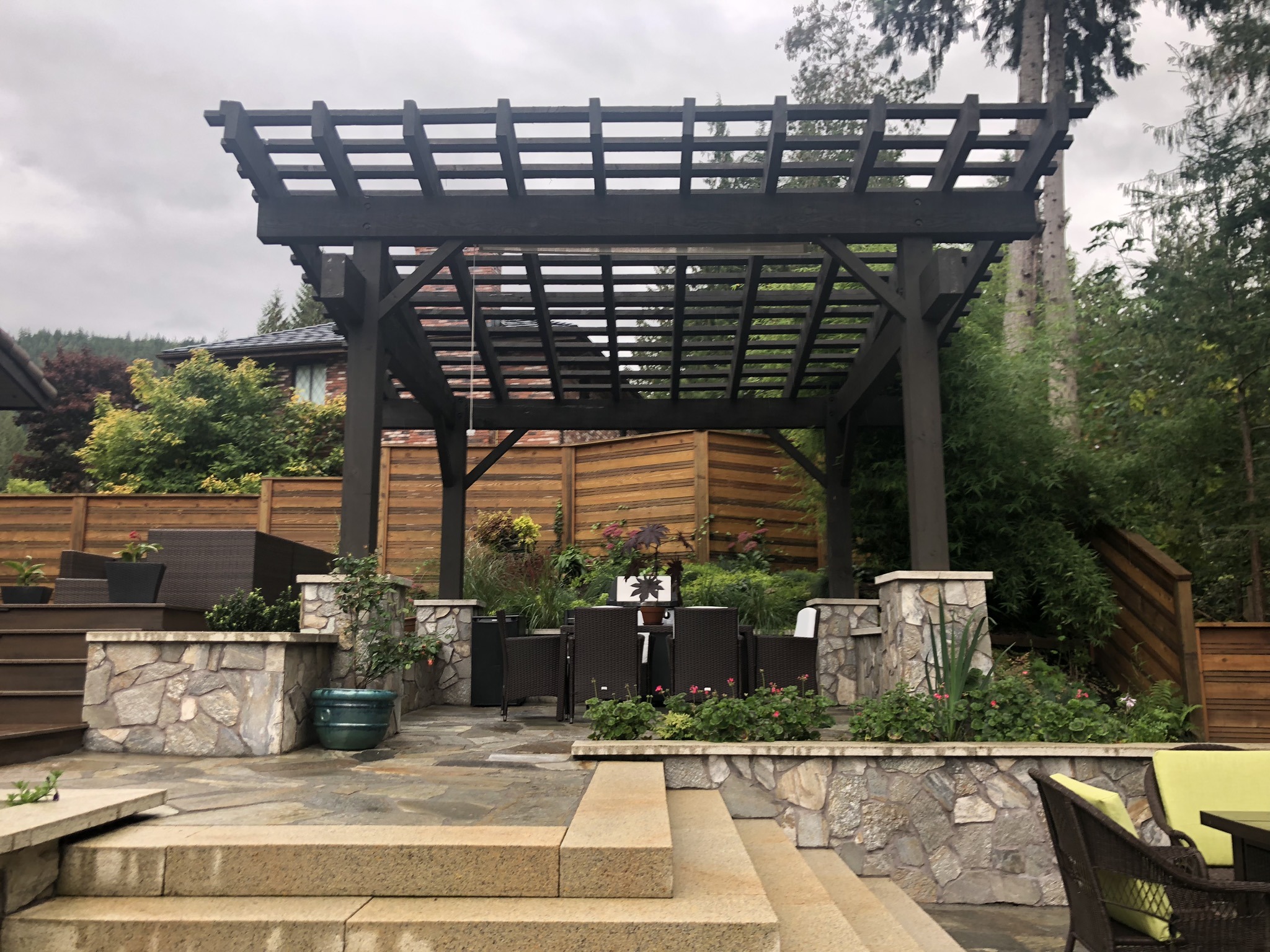 Backyard patio with wooden pergola and dining set