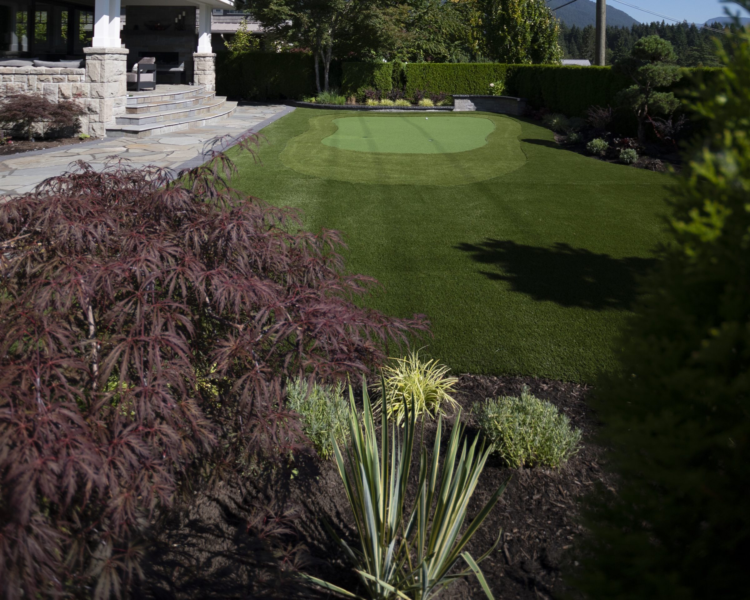 Backyard putting green beside stone patio