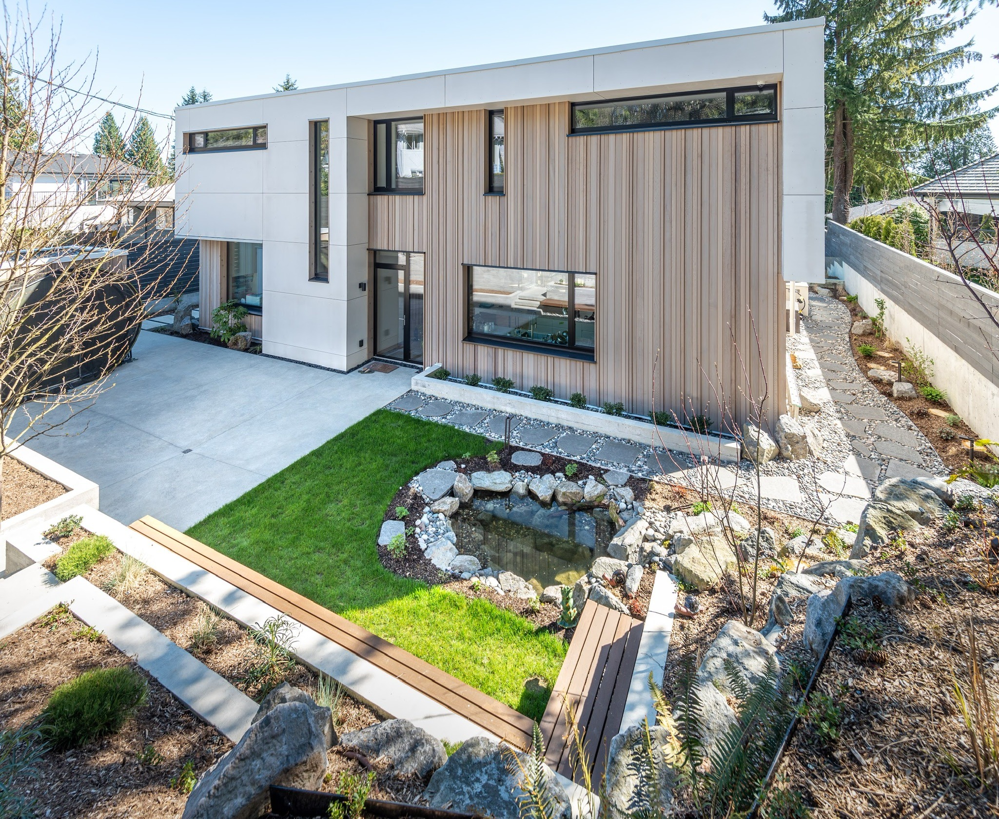 Modern two-story home with landscaped backyard and pond