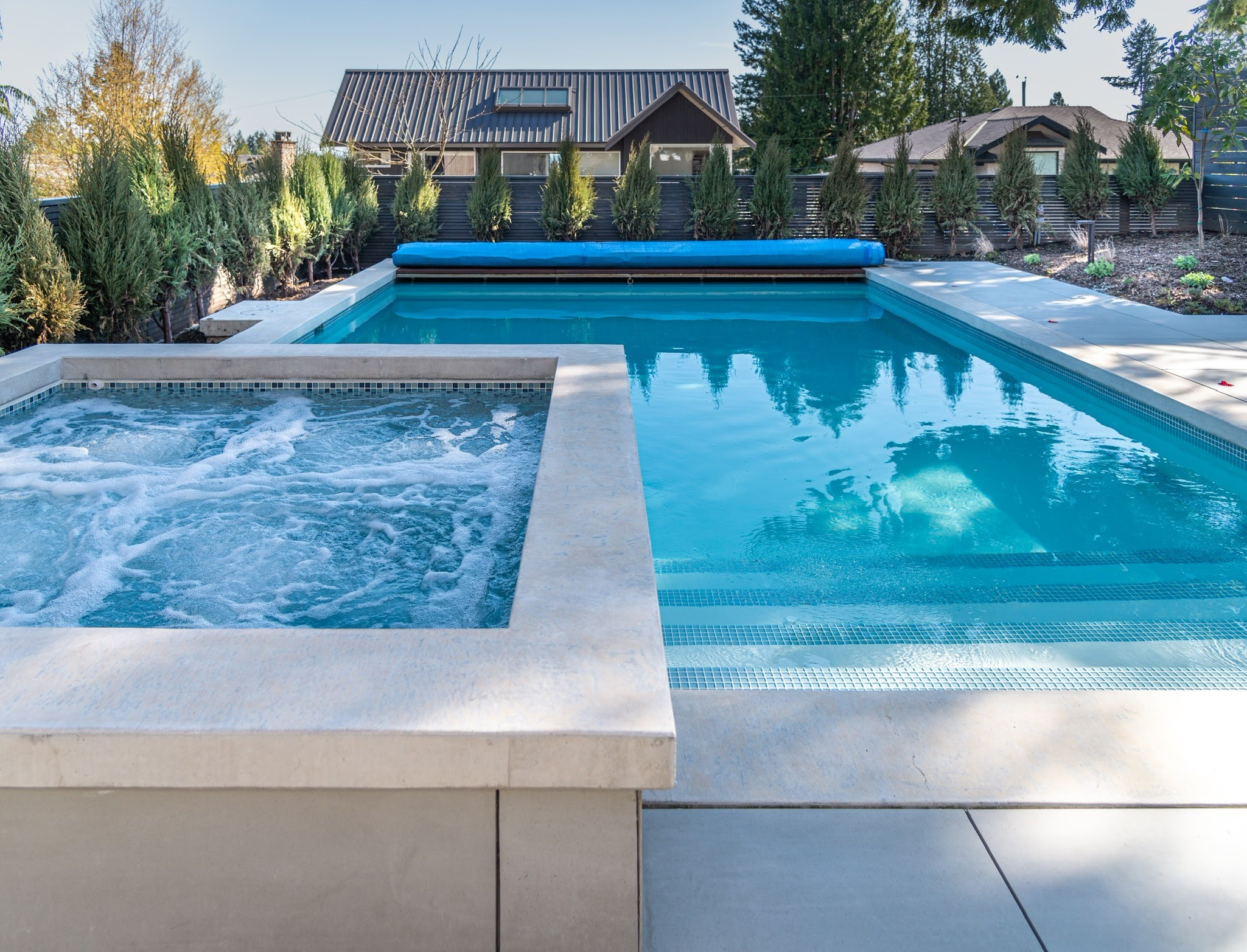 Modern backyard pool with attached hot tub