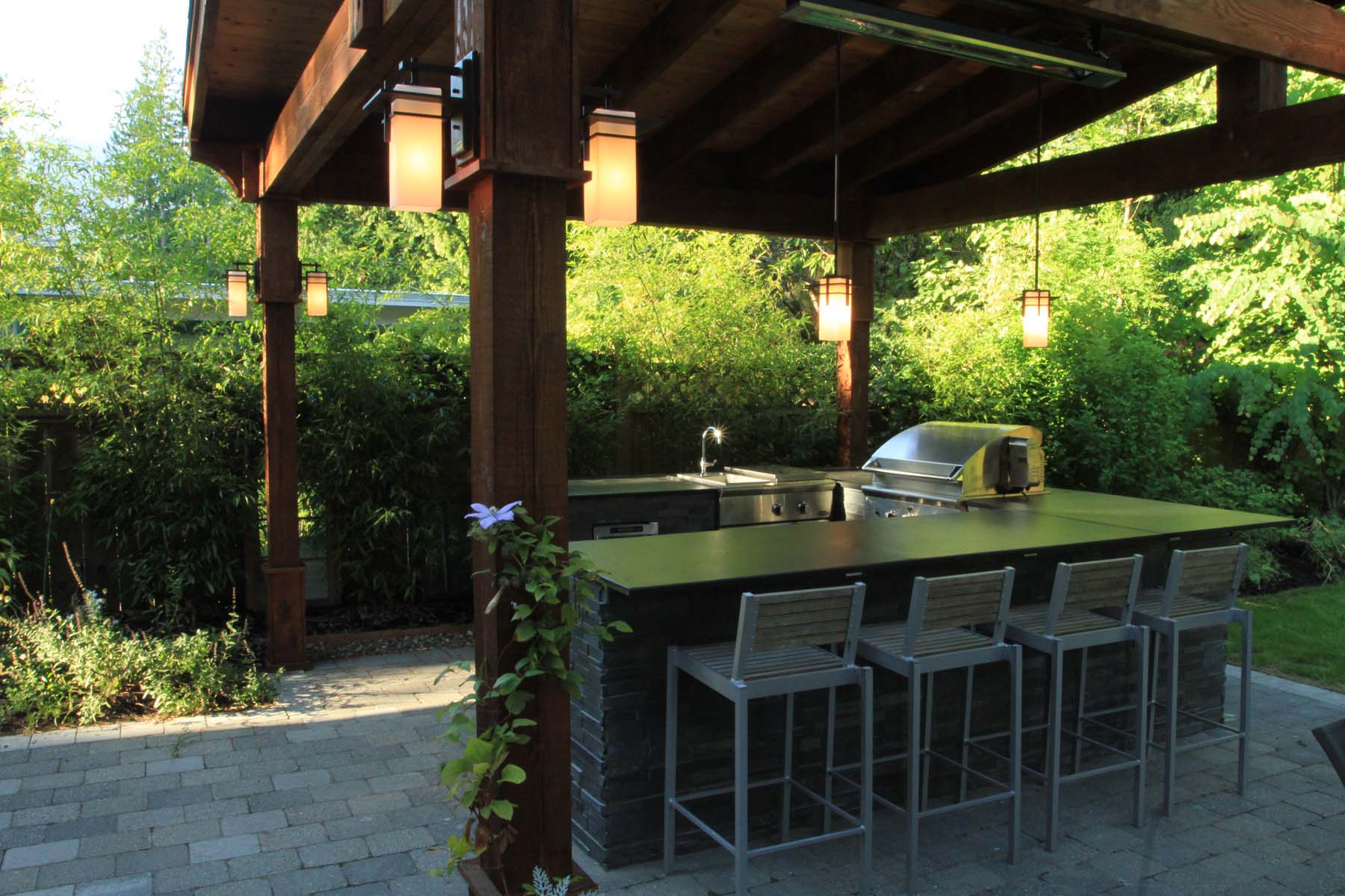 Outdoor kitchen with pergola and bar seating