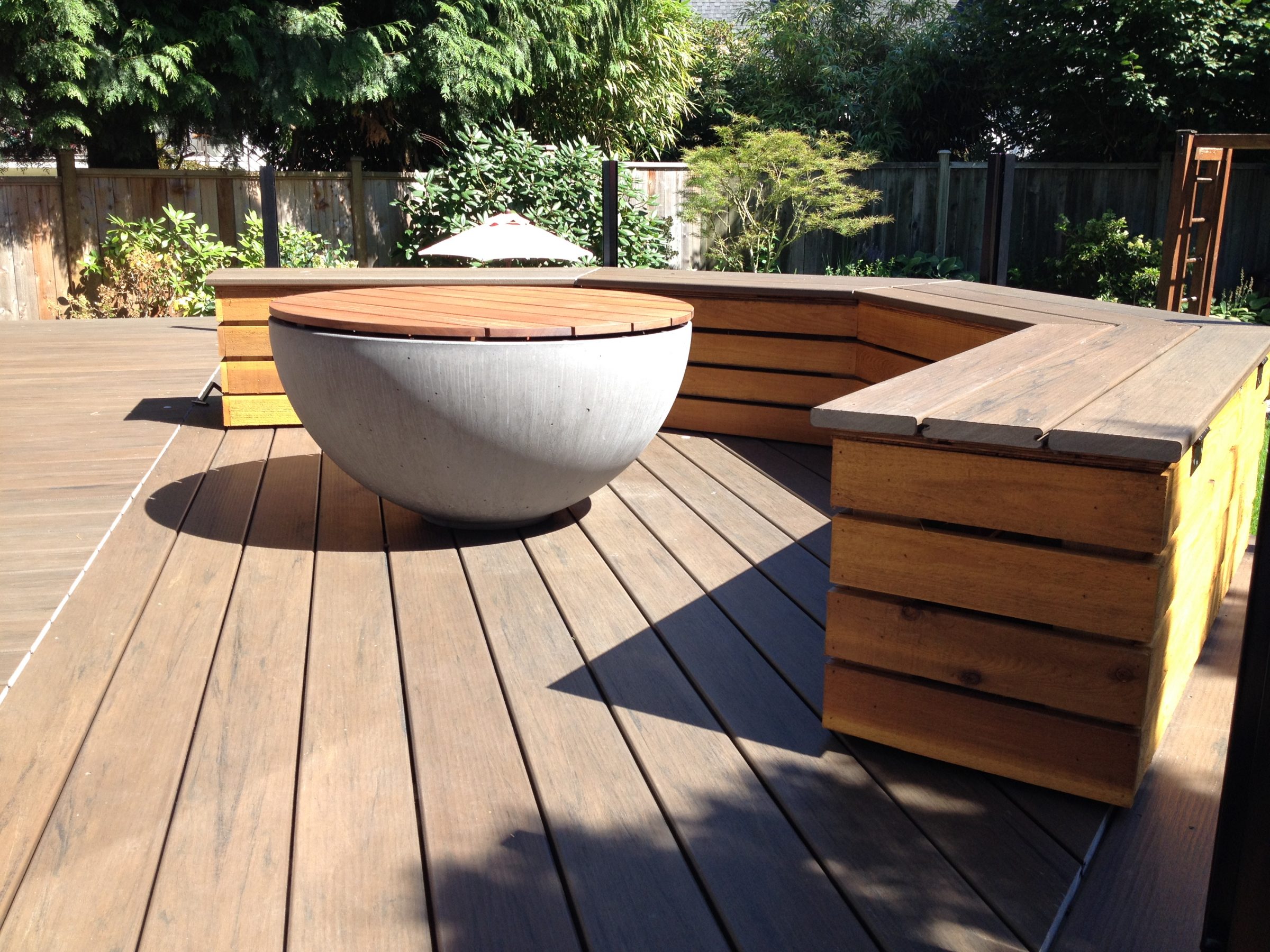 Modern backyard deck with built-in seating and fire pit