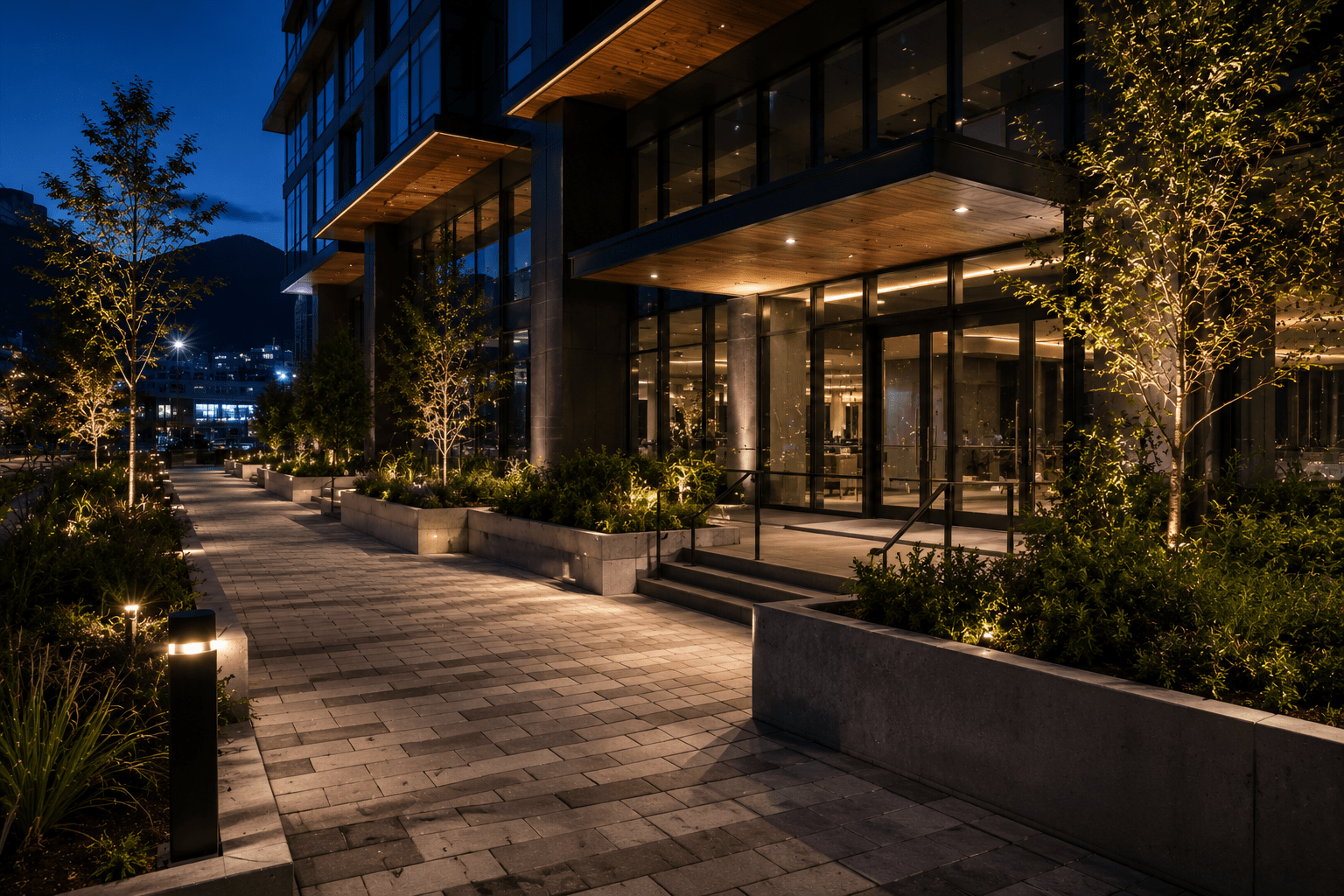 Modern building entrance with landscaped walkway at night