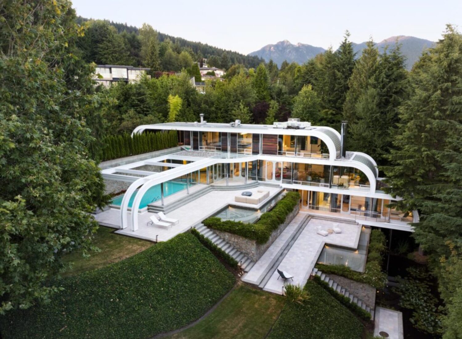 Modern hillside mansion with curved design and pool