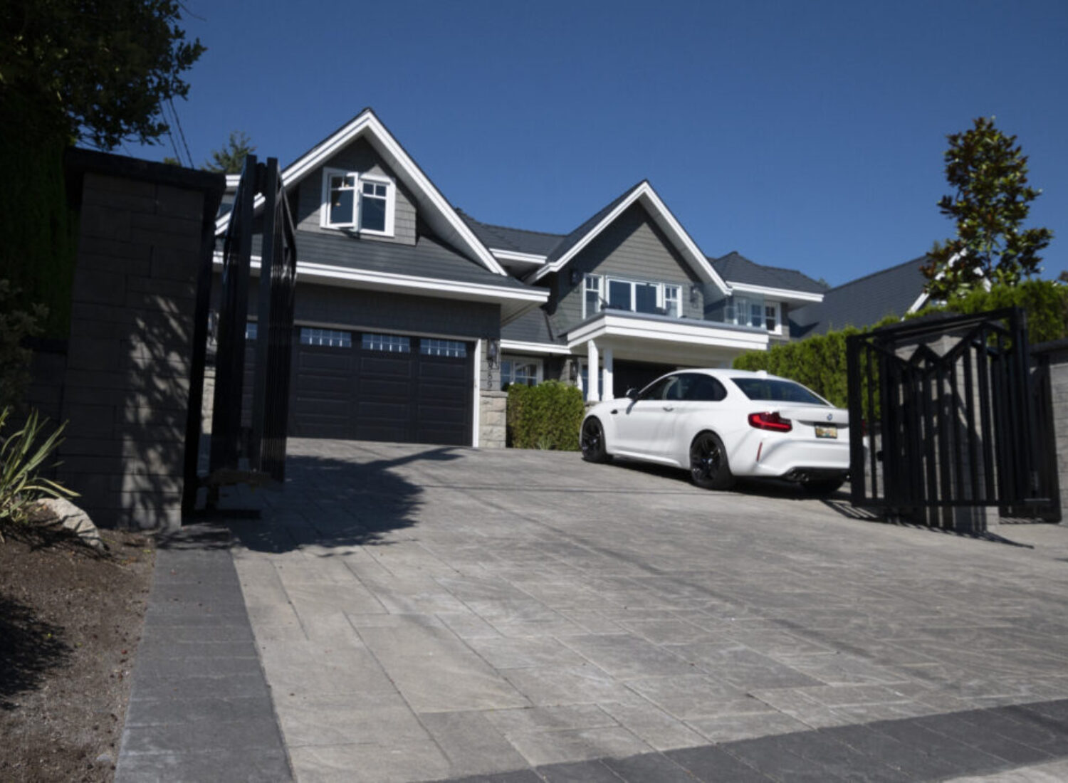 Modern gray house with white sedan driveway