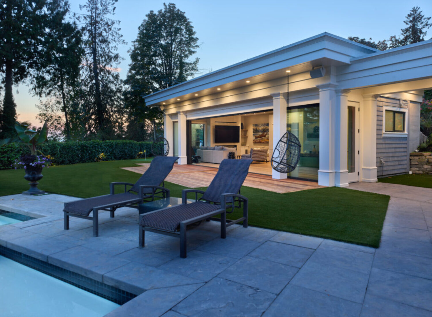 Modern backyard patio with pool and lounge chairs
