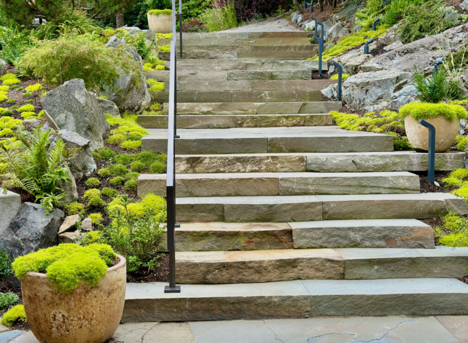 Stone garden steps with lush greenery and rocks