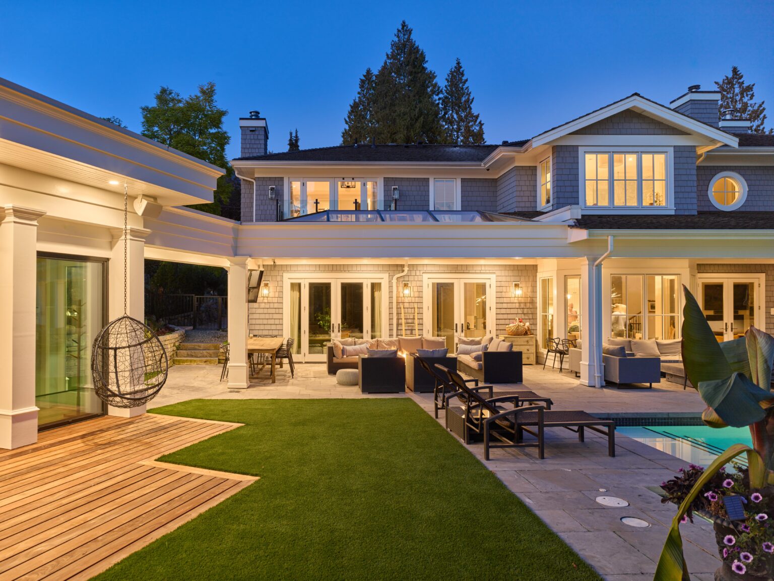 Luxury backyard patio with pool at dusk