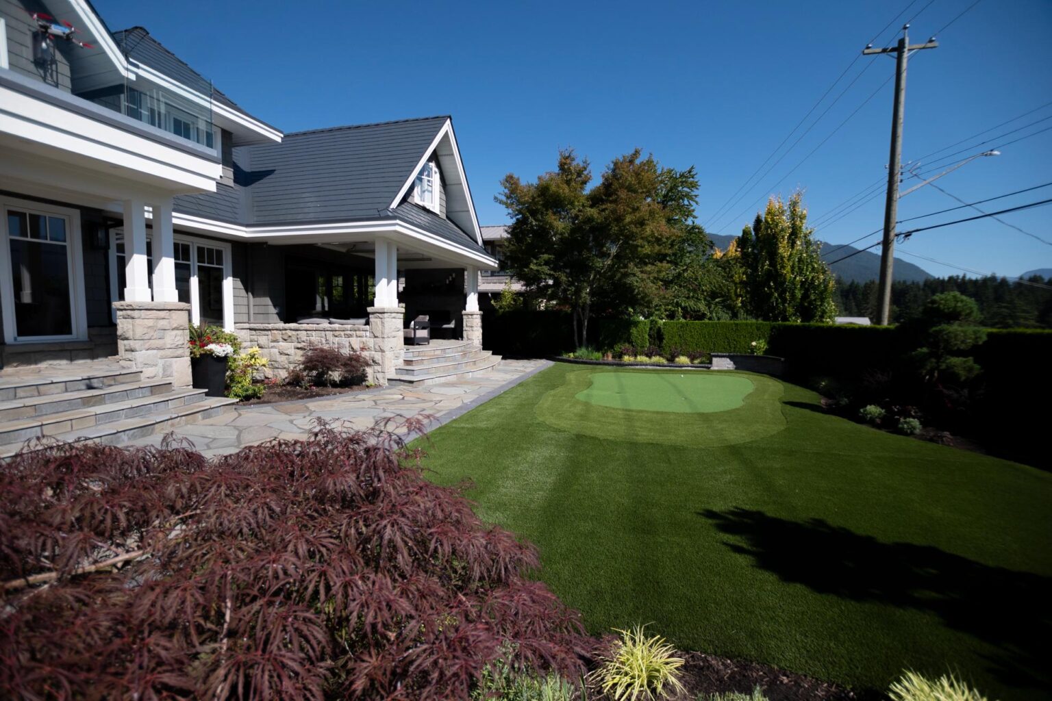 Modern home with backyard putting green and patio