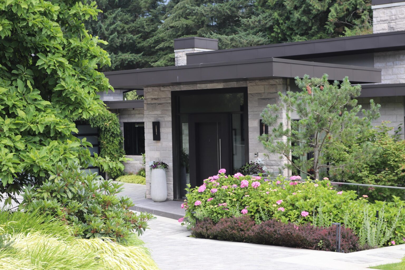 Modern stone house with lush landscaped garden entrance