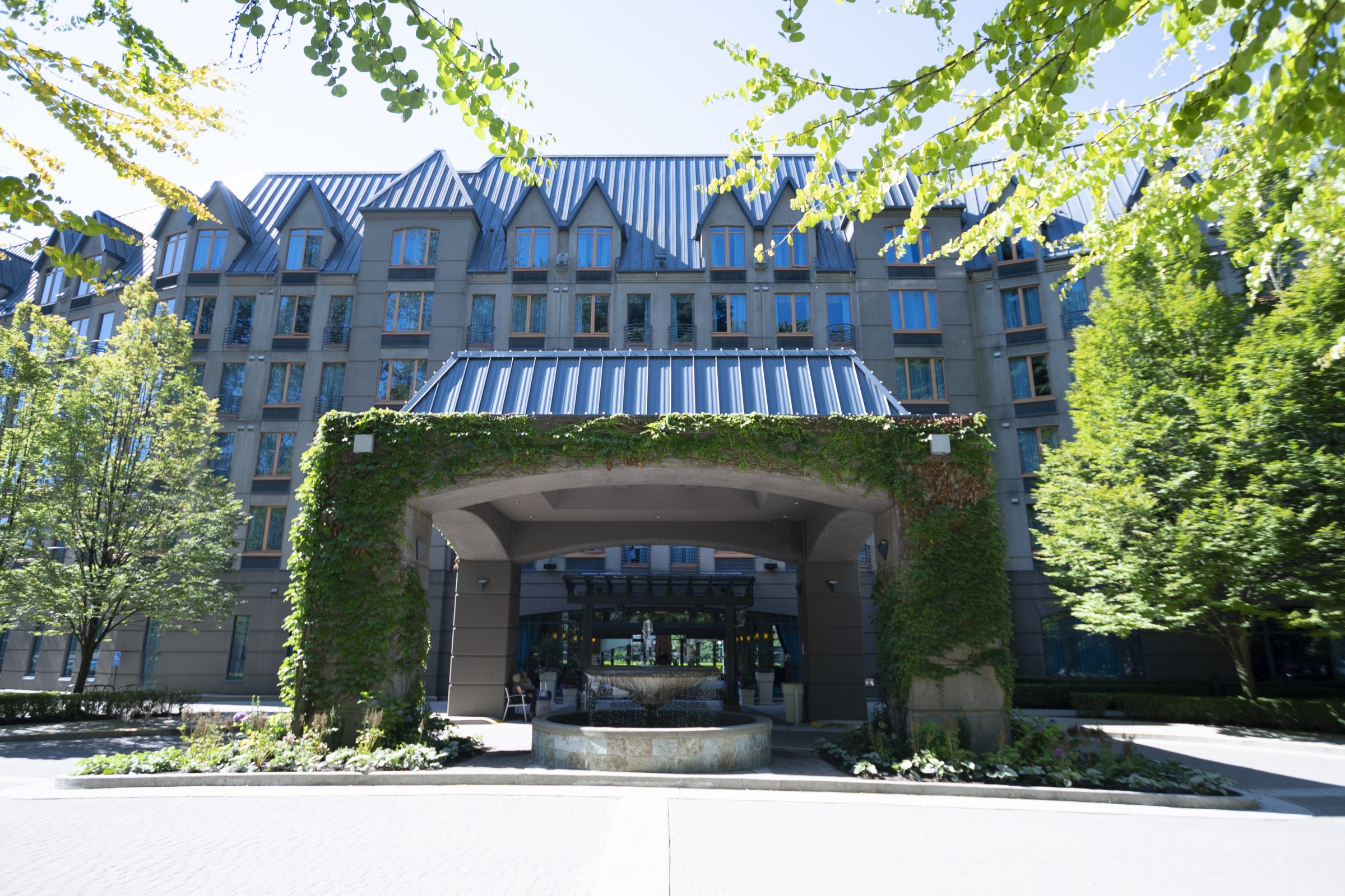 Elegant hotel entrance with fountain and ivy-covered arch