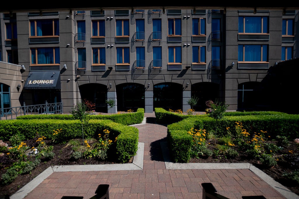 Modern hotel courtyard with hedges and balconies