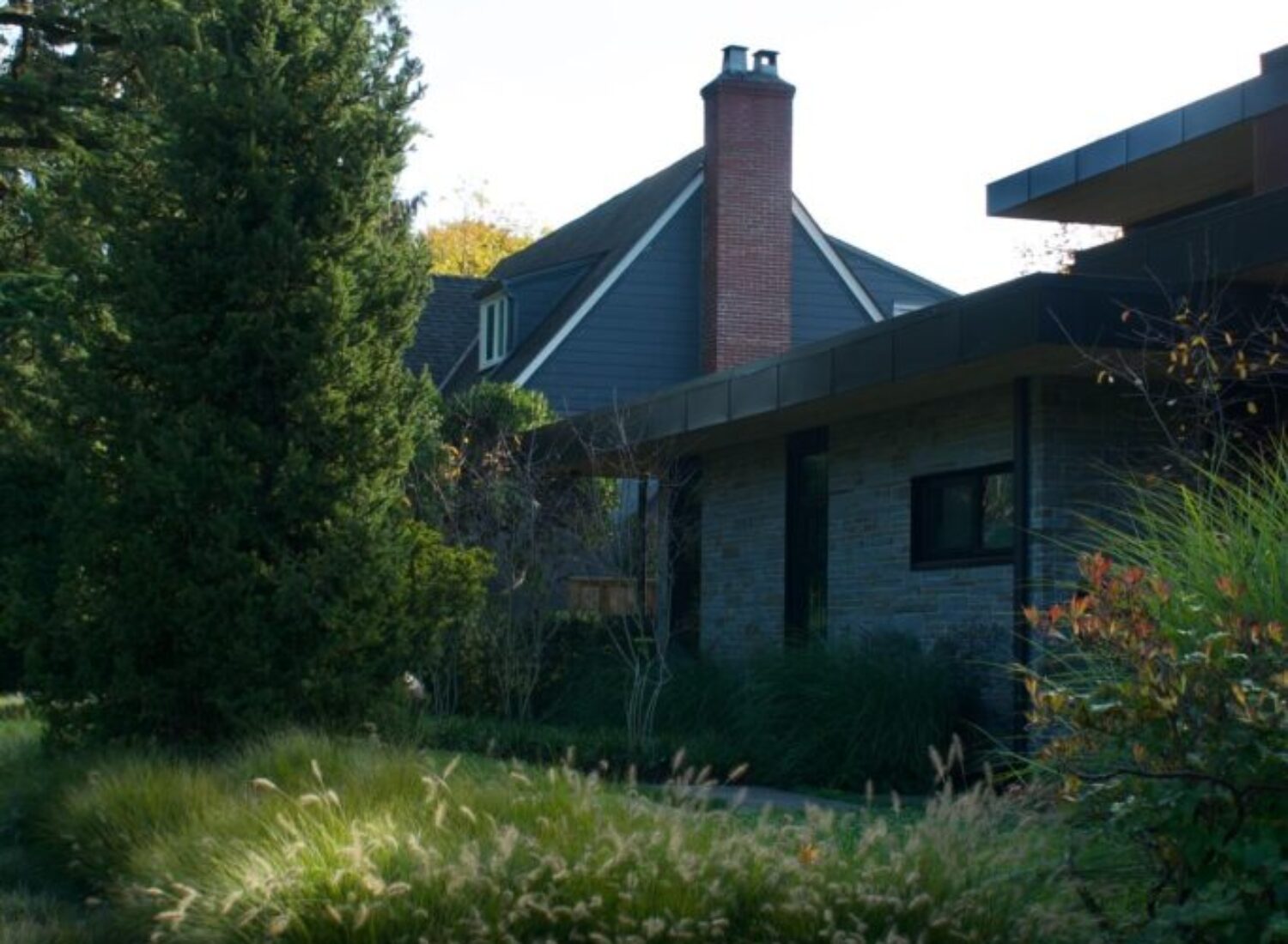 Modern house with brick chimney and lush garden