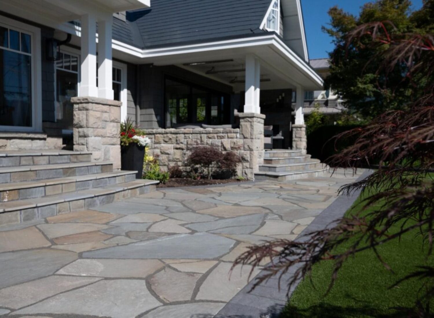 Modern home exterior with stone patio and porch