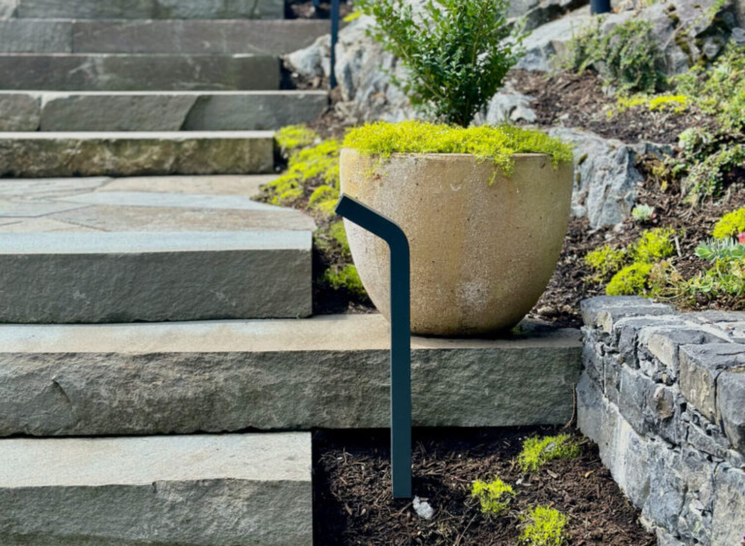 Modern stone steps with planter and metal handrail
