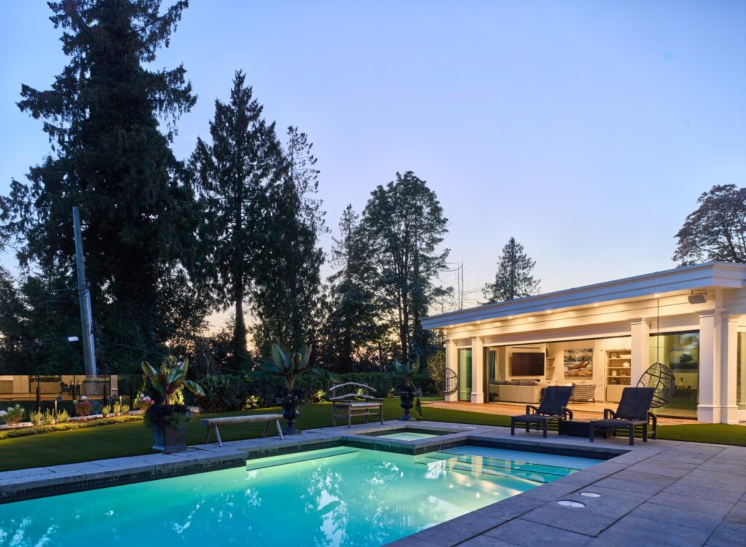 Modern backyard pool and patio at dusk