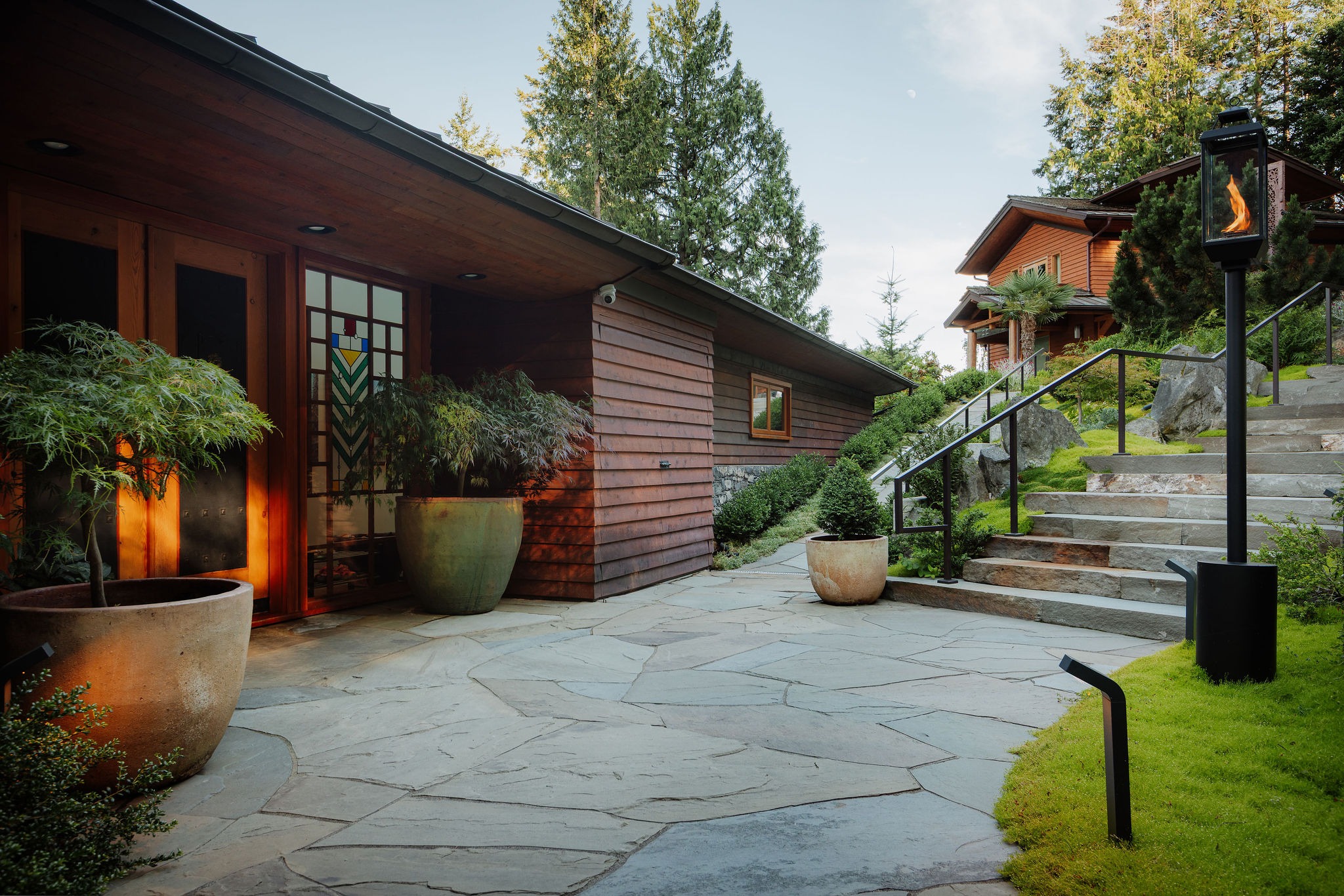 Modern wooden home with landscaped stone patio