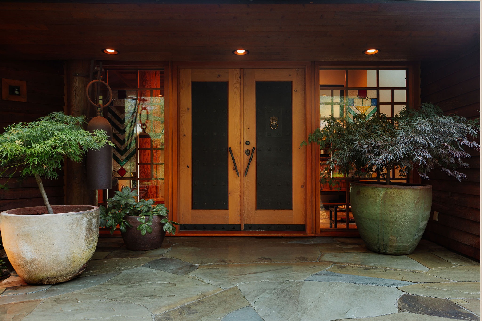 Modern wooden front door with potted plants