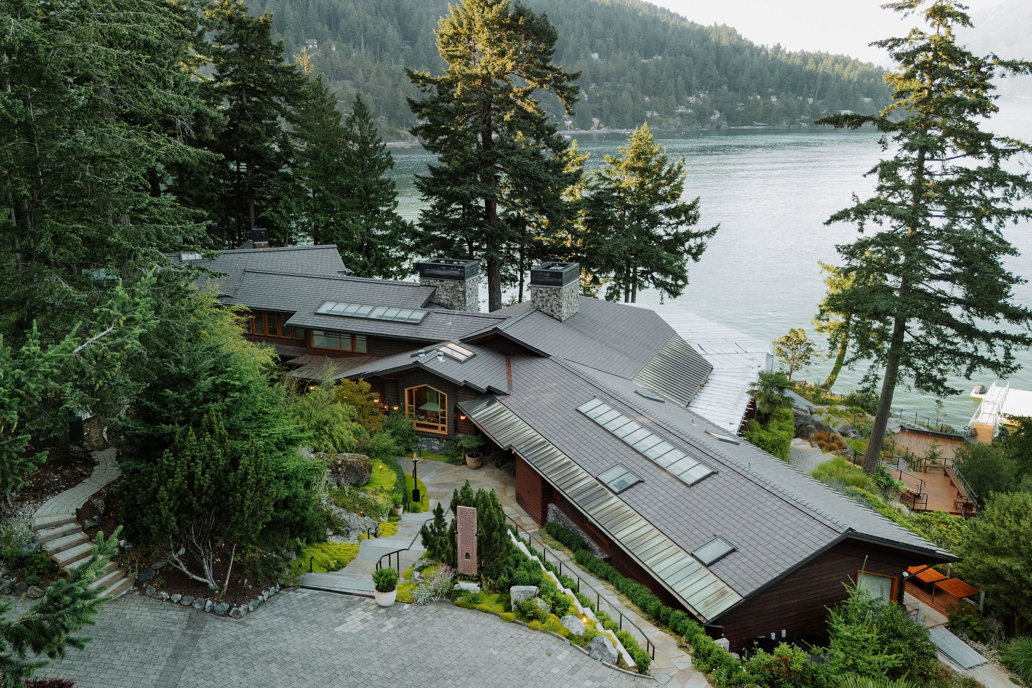 Lakeside modern home surrounded by evergreen forest
