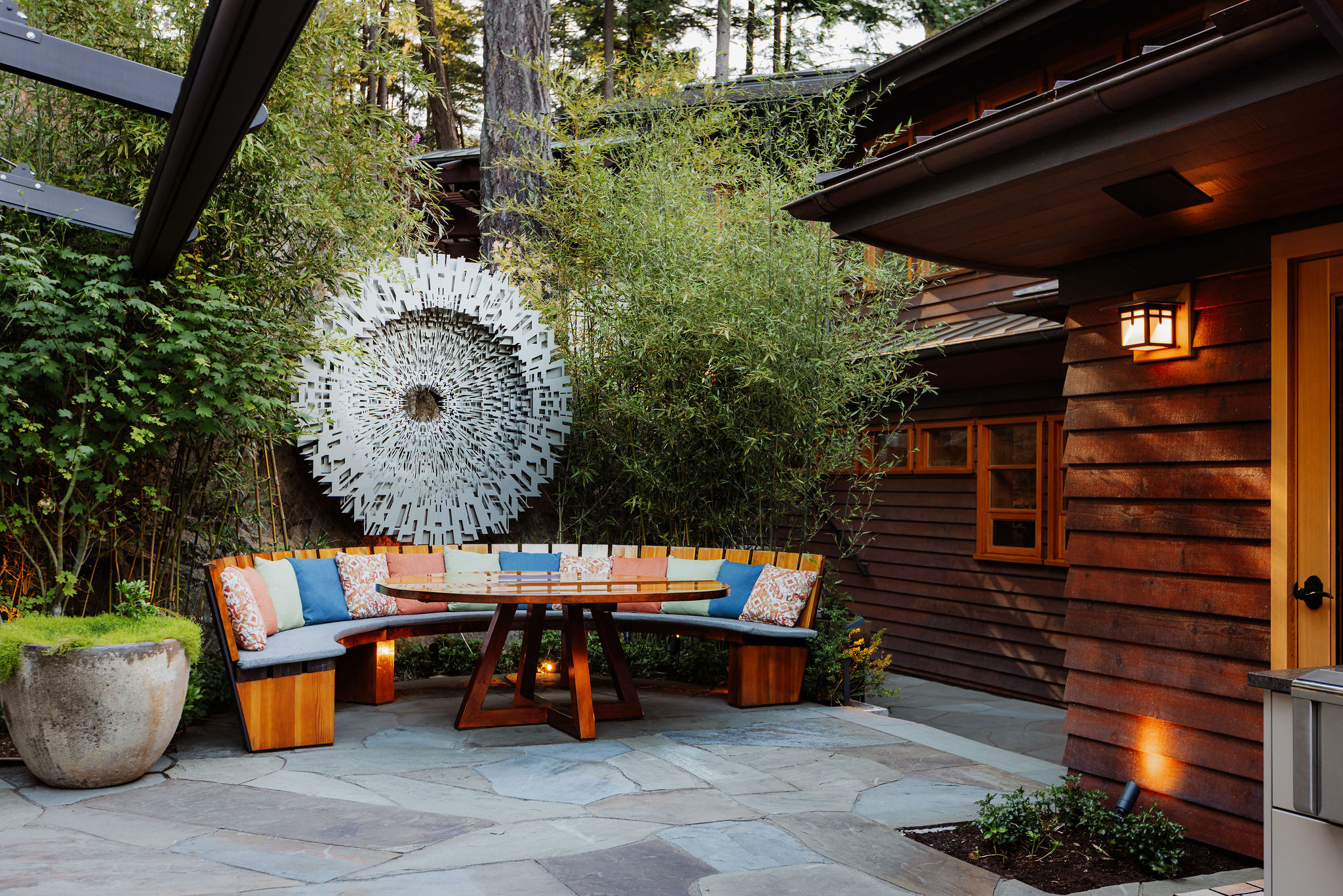 Modern outdoor patio with curved bench and wall art
